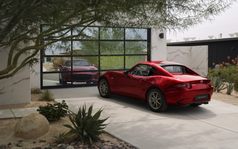 Mazda MX-5 rojo estacionado en un garaje.