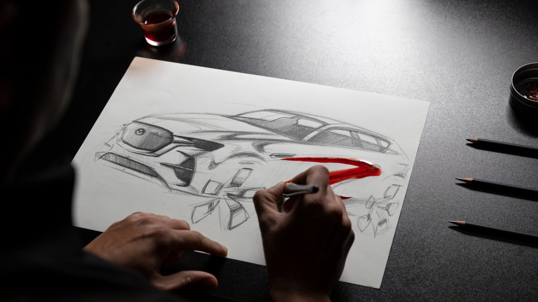 Diseñador trabajando en un boceto a lápiz de un modelo Mazda.